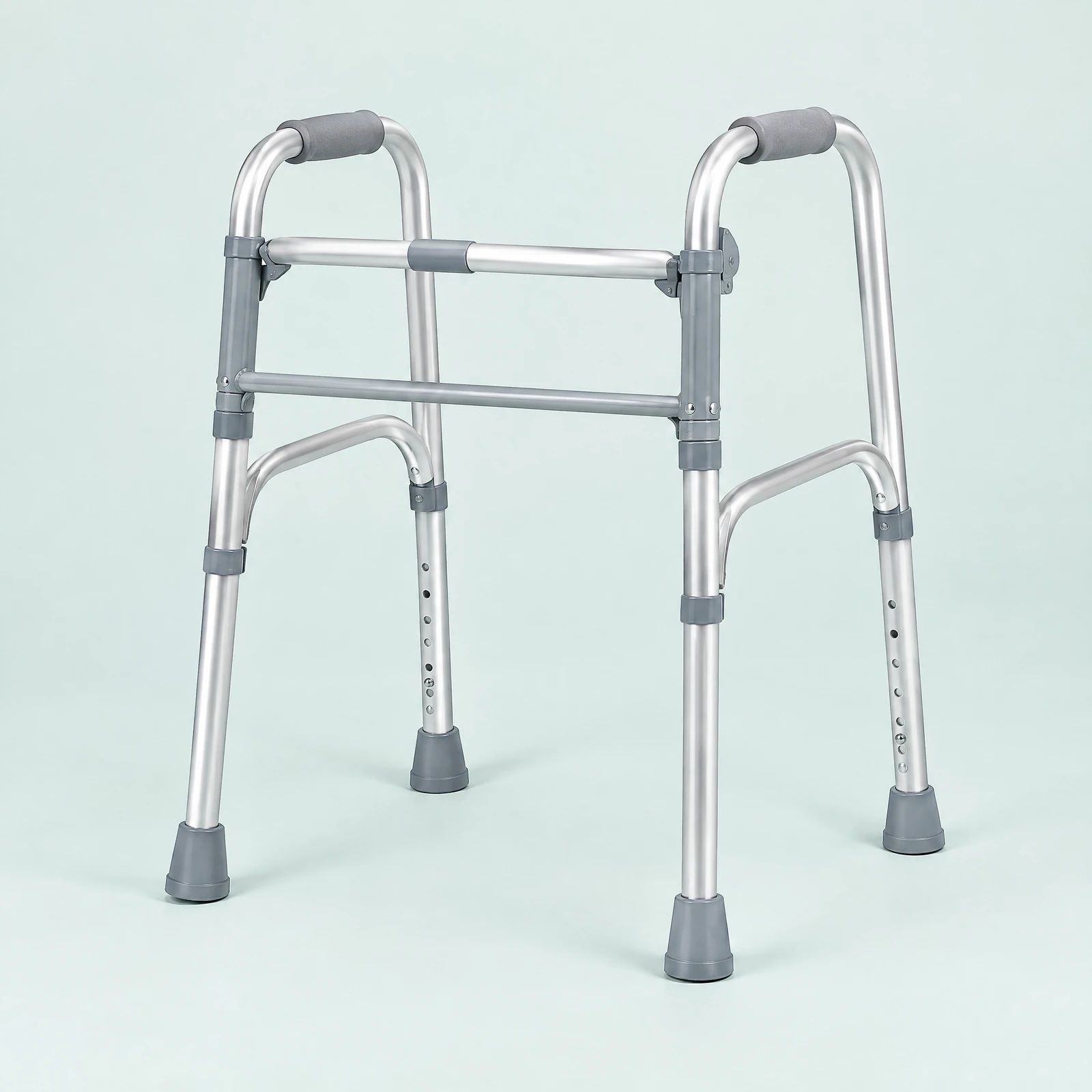 Silver-tone folding walker with four legs, gray hand grips and gray leg tips